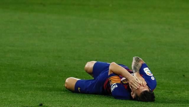 Barcelona's Lionel Messi grimaces in pain during the Spanish La Liga soccer match between RCD Espanyol and Real Madrid at the Cornella-El Prat stadium in Barcelona, Spain, Sunday, June 28, 2020. (AP Photo/Joan Monfort)