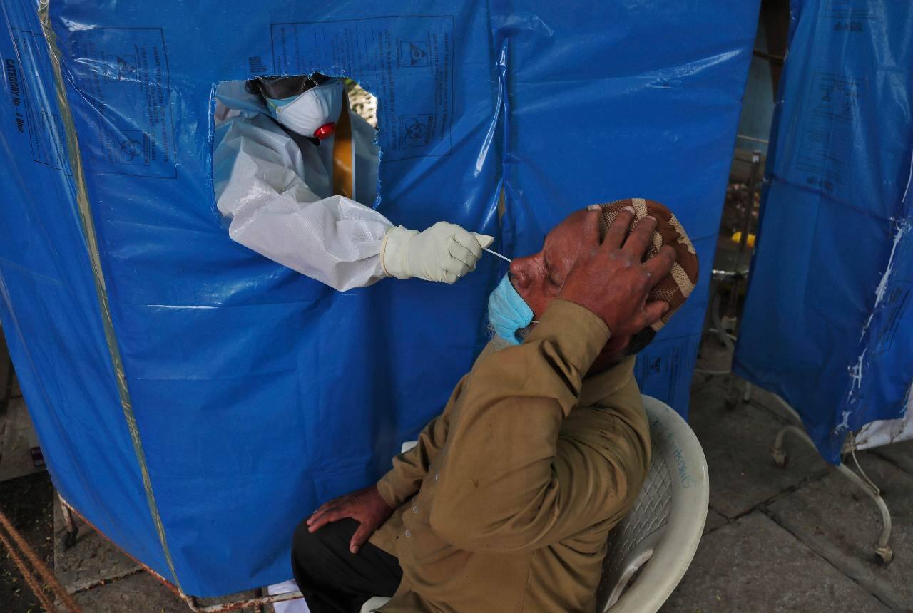 A health worker takes a nasal swab sample to test for COVID-19 in Hyderabad, India, Saturday, Aug. 22, 2020. India has the third-highest caseload after the United States and Brazil, and the fourth-highest death toll in the world. (AP Photo/Mahesh Kumar A.)