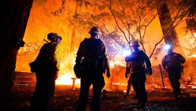 Firefighters make a stand in the backyard of a home in front of the advancing CZU August Lightning Complex Fire in Boulder Creek, California. AP