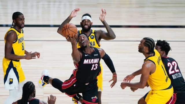 Miami Heat forward Bam Adebayo (13) makes a off-balanced shot between Indiana Pacers defenders Justin Holiday, left, JaKarr Sampson, center, and T.J. Warren (1) during the second half of an NBA basketball first round playoff game, Tuesday, Aug. 18, 2020, in Lake Buena Vista, Fla. (AP Photo/Ashley Landis, Pool)