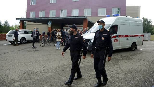 Police patrol the area as journalists gather at the hospital where Alexei Navalny was hospitalized in Omsk, Russia. AP
