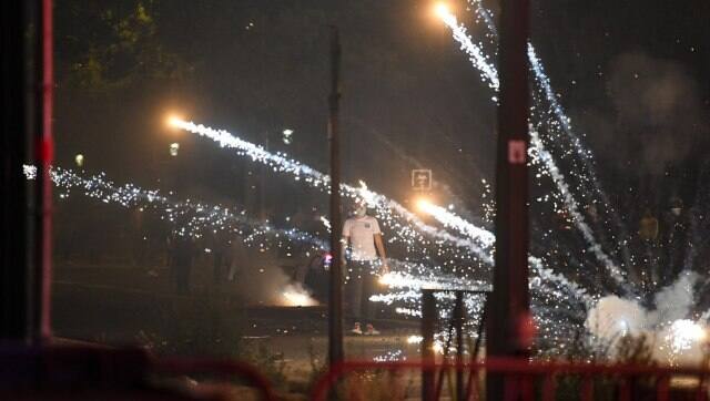 A man stands among tear gas smokes fired by French anti-riot policemen escorting PSG supporters around the Parc des Princes. AFP