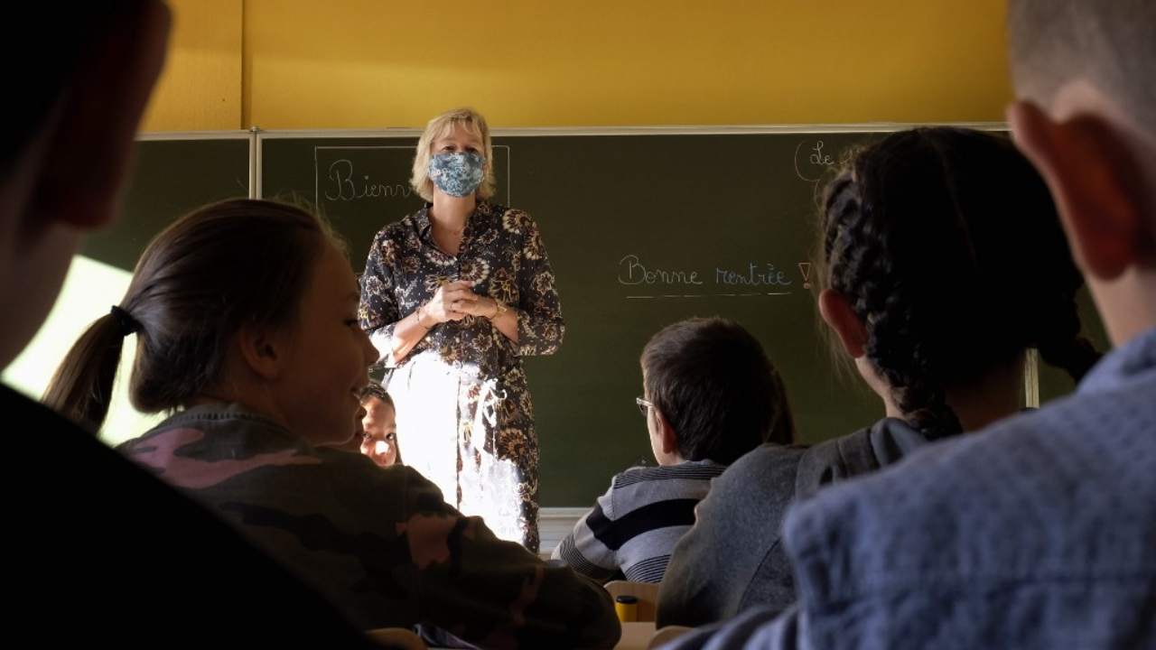 Pupils listen to a teacher wearing a mask in the classroom in a school in Helecine, Belgium on 1 September 2020, on the first day of school year amid the Covid-19 epidemic. AFP