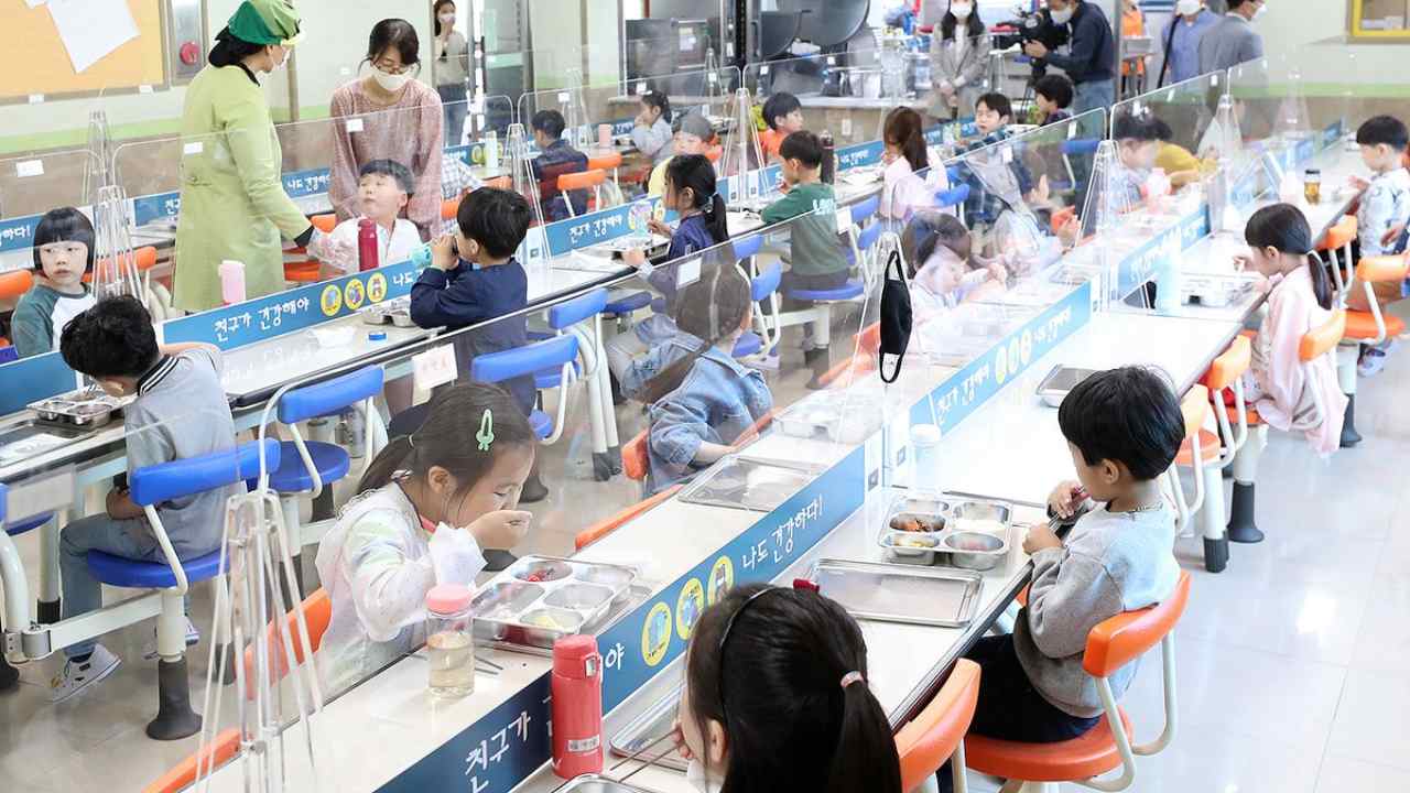 Students having lunch with transparent dividers separating them at the canteen of an elementary school in South Korea, in May. Image: Twitter/Jeff Ballinger