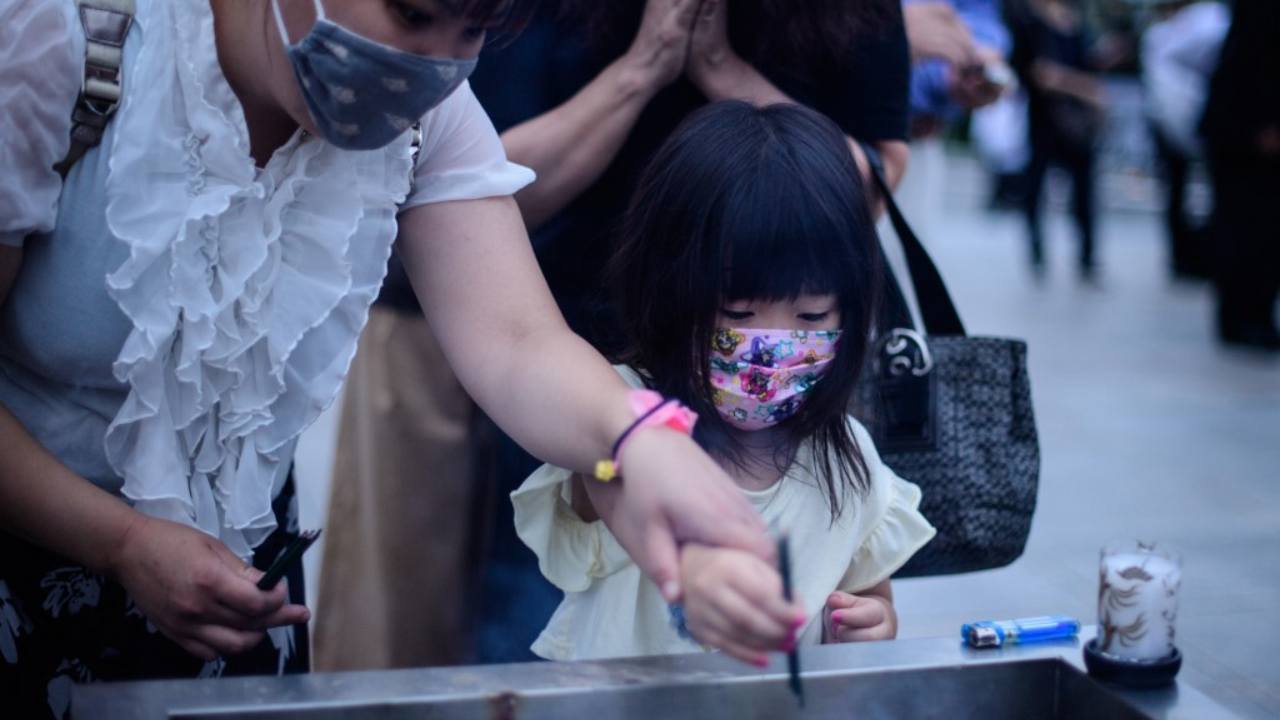Visitors burn incense to pay tribute to the atomic bomb victims in front of the cenotaph at the Hiroshima Peace Memorial Park in Hiroshima on 6 August. AFP