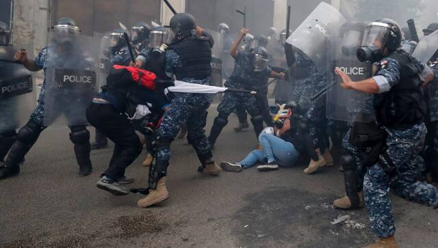Riot policemen beat anti-government protesters during a protest near Parliament Square, in Beirut, Lebanon. AP
