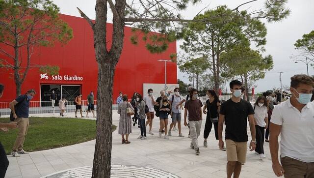 Festival workers leave a meeting where they were briefed about procedures for the 77th edition of the Venice Film Festival at the Venice Lido, Italy, Monday, Aug. 31, 2020. The festival will take place from 2 to 12 September. in a more restrained format due the COVID-19 pandemic. (AP Photo/Domenico Stinellis)