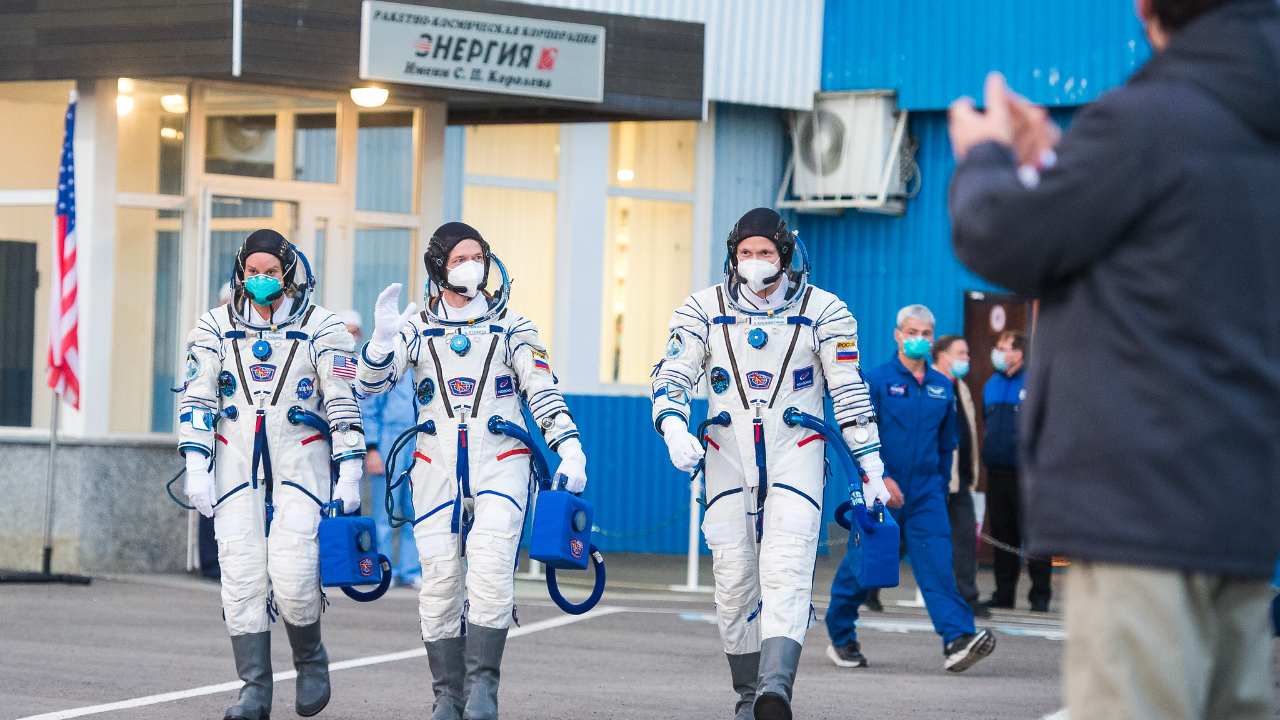 Expedition 64 NASA astronaut Kate Rubins, left, and Russian cosmonauts Sergey Ryzhikov, center, and Sergey Kud-Sverchkov, right, of Roscosmos are seen as they depart Building 254 to head to their launch onboard the Soyuz MS-17 spacecraft. Image credit: NASA/GCTC/Andrey Shelepin