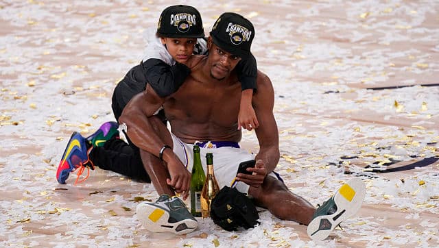 Los Angeles Lakers’ Rajon Rondo sits in the confetti with his son Rajon Jr after the Lakers defeated the Miami Heat on Sunday. AP Photo