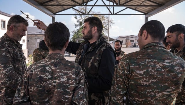 A priest offering blessings to volunteer soldiers at a military base. Sergey Ponomarev/The New York Times