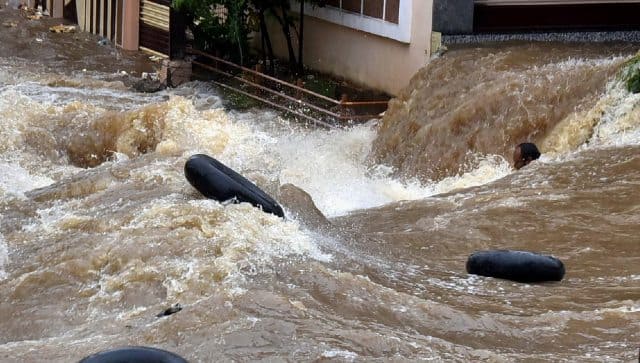 A man struggles to stay afloat in gushing floodwater following heavy rains, at Falaknuma, in Hyderabad. PTI