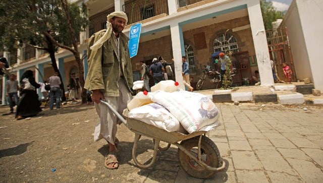 A file image of a displaced Yemeni from the year 2019, carrying food aid provided by the World Food Program, at a school in Sanaa, Yemen. AP 