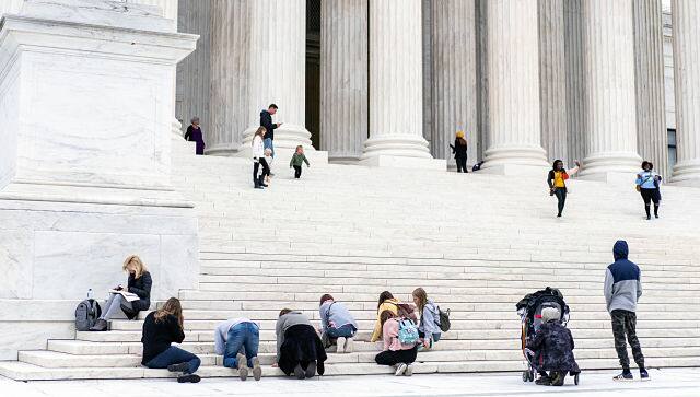 Supporters of Judge Amy Coney Barrett kneel to pray on the steps of the Supreme Court. By Anna Moneymaker © 2020 The New York Times