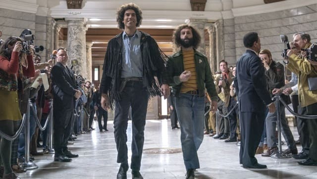 Sacha Baron Cohen as Abbie Hoffman and Jeremy Strong as Jerry Rubin