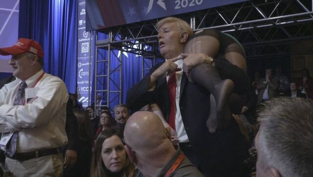 Sacha Baron Cohen in a Donald Trump mask and suit