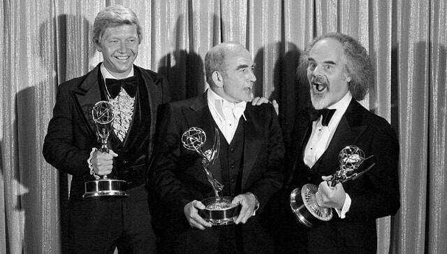 In this Sunday, Sept. 11, 1977 file photo, Screenwriter William Blinn, left, Ed Asner, center, and David Greene pose with their Emmy statuettes at the annual Primetime Emmy Awards presentation in Los Angeles. (AP Photo/File)