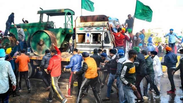 Members of various farmer organisations remove a barricade at Punjab-Haryana border in Ambala district as they march towards Delhi over recent farm laws. PTI