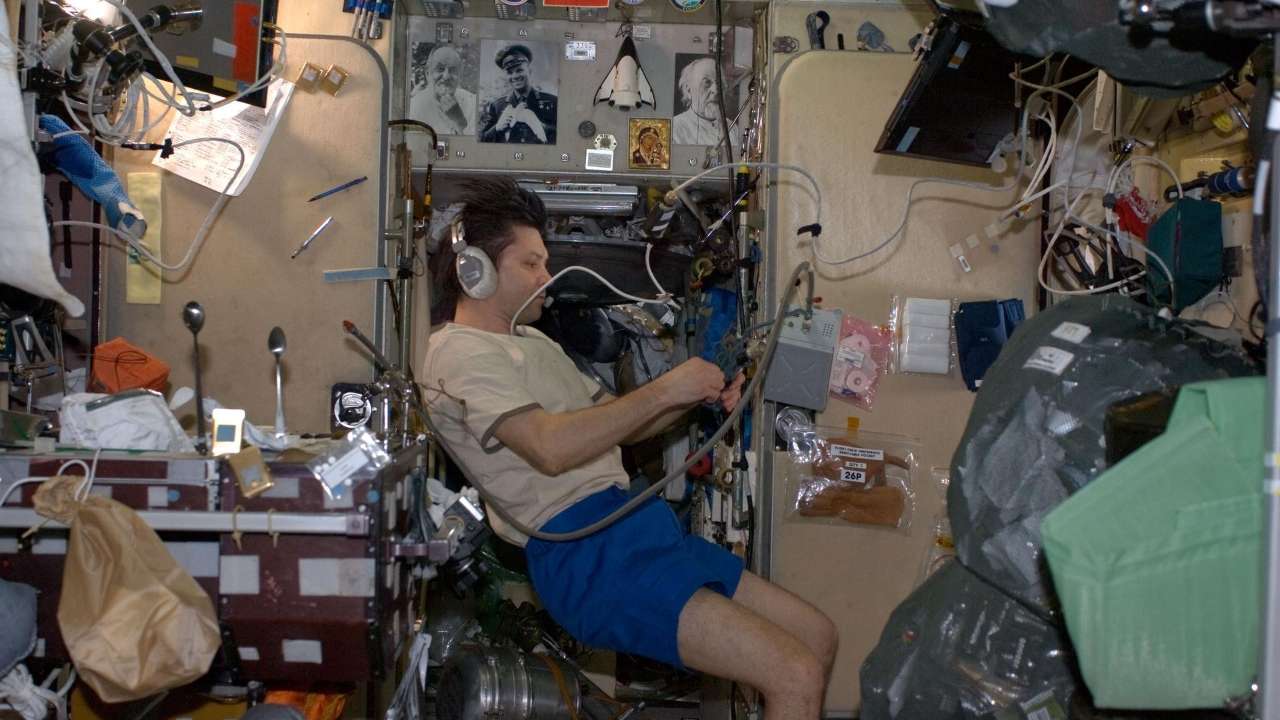 Oleg Kononenko in the Zvezda module in 2008, showing icons and space heroes pinned on the wall in the background. Image credit: NASA