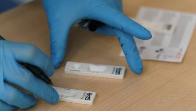A healthcare worker conducts an antigen rapid test for COVID-19 during a mass screening for coronavirus. AFP