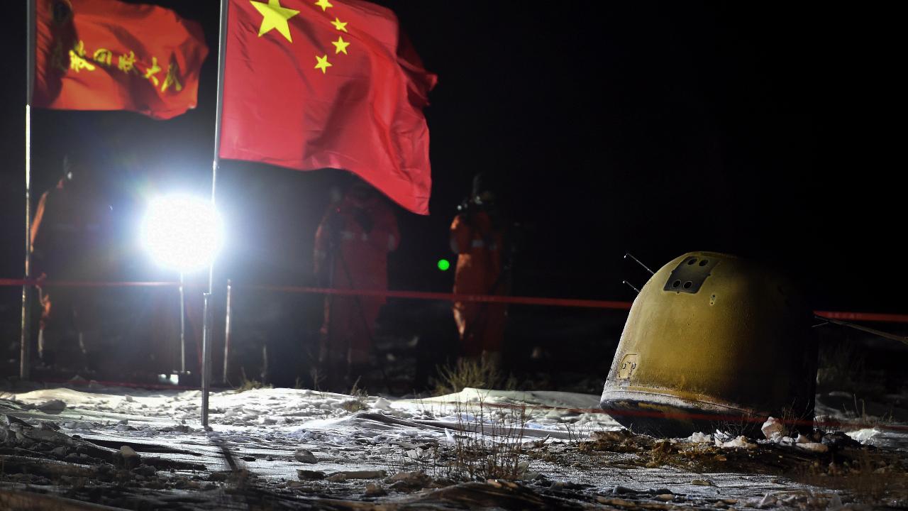In this photo released by Xinhua News Agency, crew members film the capsule of the Chang’e 5 probe after its successful landed in Siziwang Banner, north China's Inner Mongolia Autonomous Region on Thursday, Dec. 17, 2020. A Chinese lunar capsule returned to Earth on Thursday with the first fresh samples of rock and debris from the moon in more than 40 years. (Ren Junchuan/Xinhua via AP)