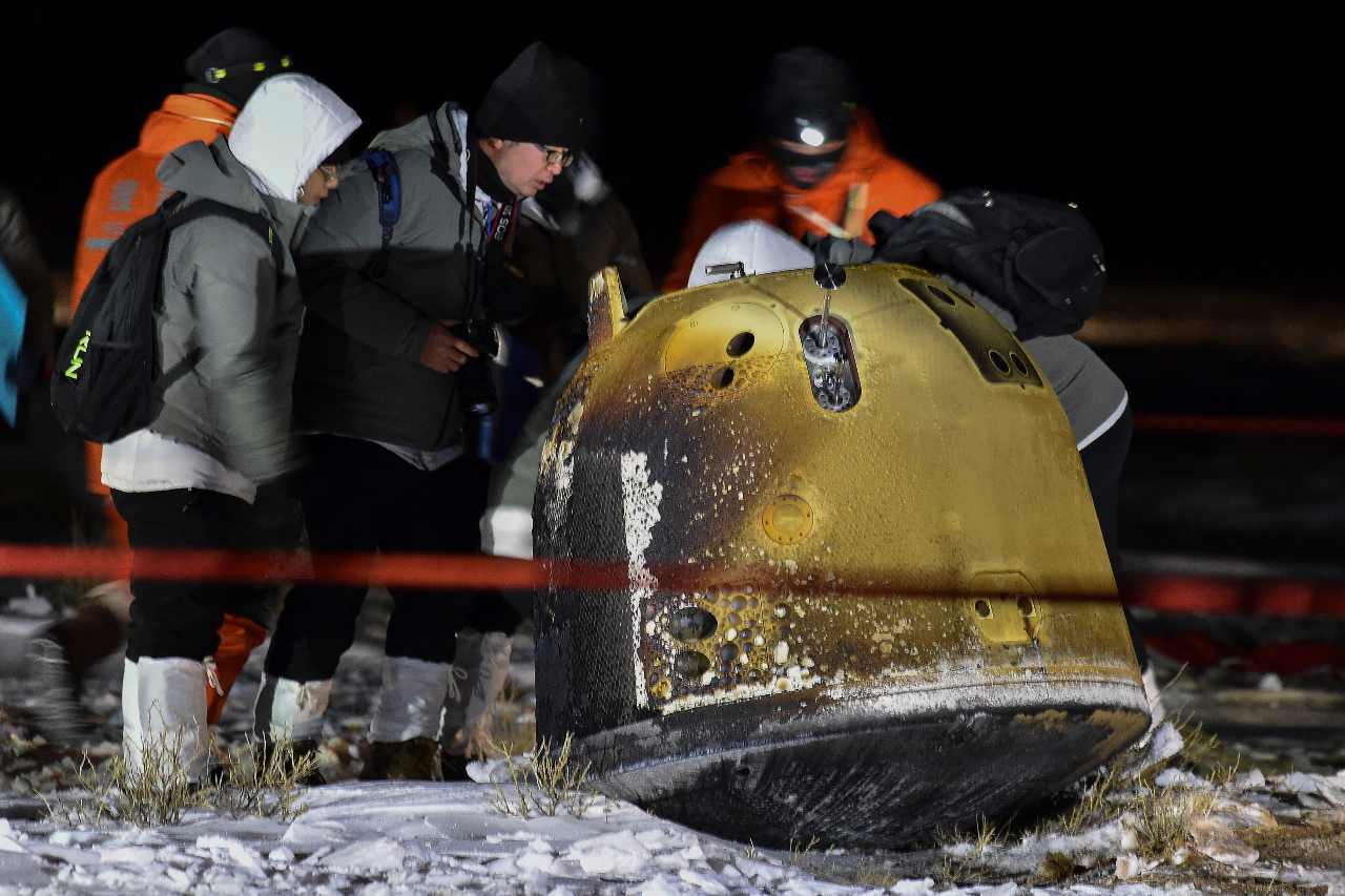 In this photo released by Xinhua News Agency, crew members check on the capsule of the Chang’e 5 probe after its successful landed in Siziwang Banner, north China's Inner Mongolia Autonomous Region on Thursday, Dec. 17, 2020. A Chinese lunar capsule returned to Earth on Thursday with the first fresh samples of rock and debris from the moon in more than 40 years. (Ren Junchuan/Xinhua via AP)