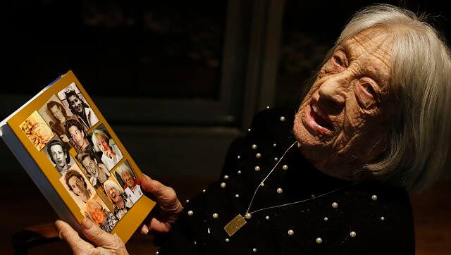 Agnes Keleti holds a book with portraits of her on the back cover in Budapest. AP Photo