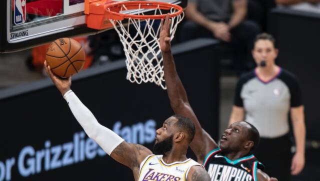 Los Angeles Lakers forward LeBron James (23) shoots past Memphis Grizzlies center Gorgui Dieng (14) during the first half of an NBA basketball game Sunday, Jan. 3, 2021, in Memphis, Tenn. (AP Photo/Wade Payne)