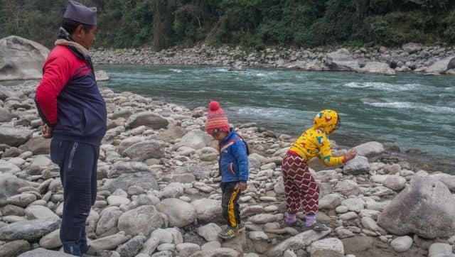 Purna Bahadur Ale watches his grandchildren playing on the bank of the Budhi Gandaki River in the Gorkha district of Nepal. The place will be submerged in water. Photo by Nabin Baral/ The Third Pole