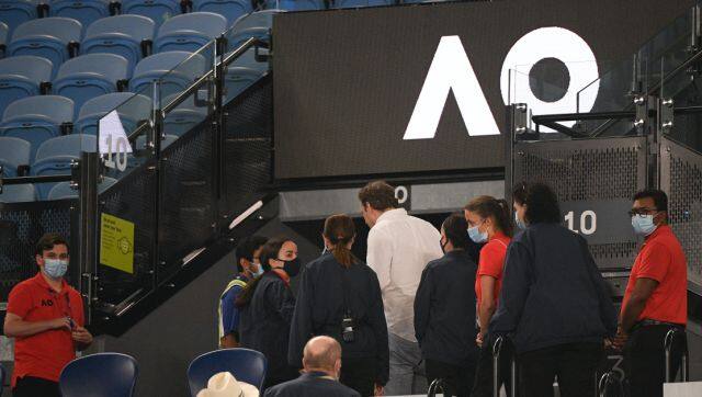 Security usher spectators from Rod Laver Arena during the third round match between Serbia's Novak Djokovic and United States' Talyor Fritz at the Australian Open tennis championship in Melbourne, Australia, Friday, Feb. 12, 2021. Melbourne, Australia's second-largest city, will begin its third lockdown on midnight Friday due to a rapidly spreading COVID-19 cluster centered on hotel quarantine.(AP Photo/Andy Brownbill)