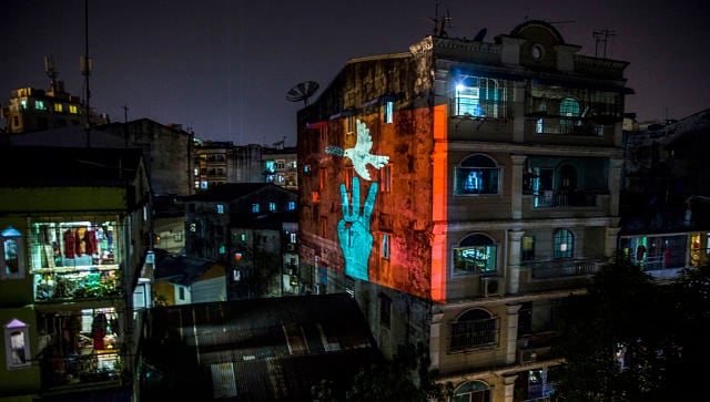 A projection in Yangon of three fingers raised in a rebellious pose and a peace dove by a filmmaker who wishes to remain anonymous. © 2021 The New York Times