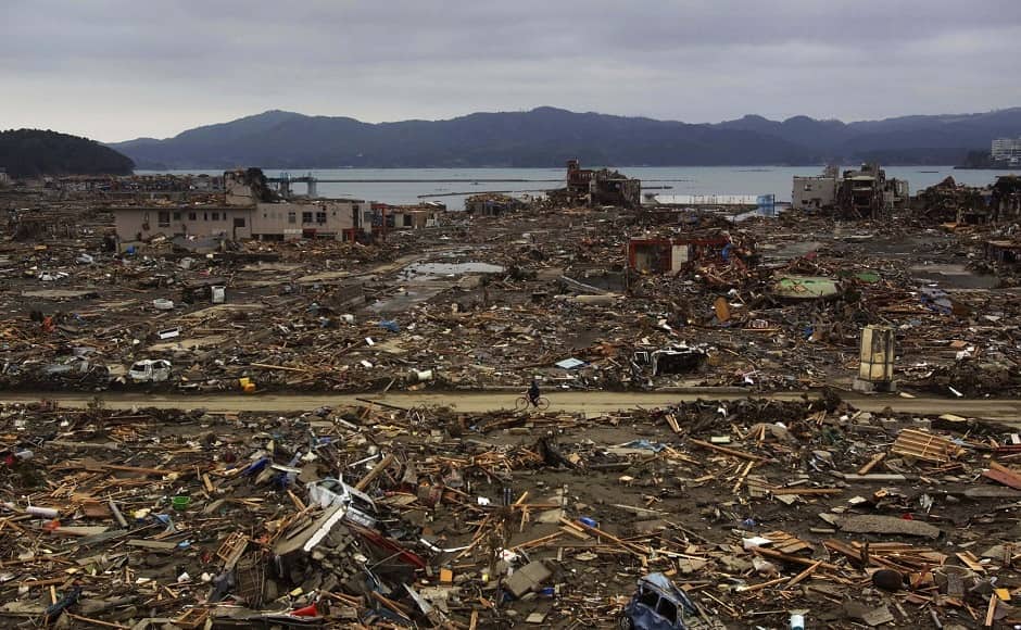 A survivor of the earthquake and tsunami rides his bicycle through wreckage in northeastern Japan, on 15 March, 2011, four days after the Tsunami. Image via The Associated Press/David Guttenfelder A survivor of the earthquake and tsunami rides his bicycle through wreckage in northeastern Japan, on 15 March, 2011, four days after the Tsunami. Image via The Associated Press/David Guttenfelder