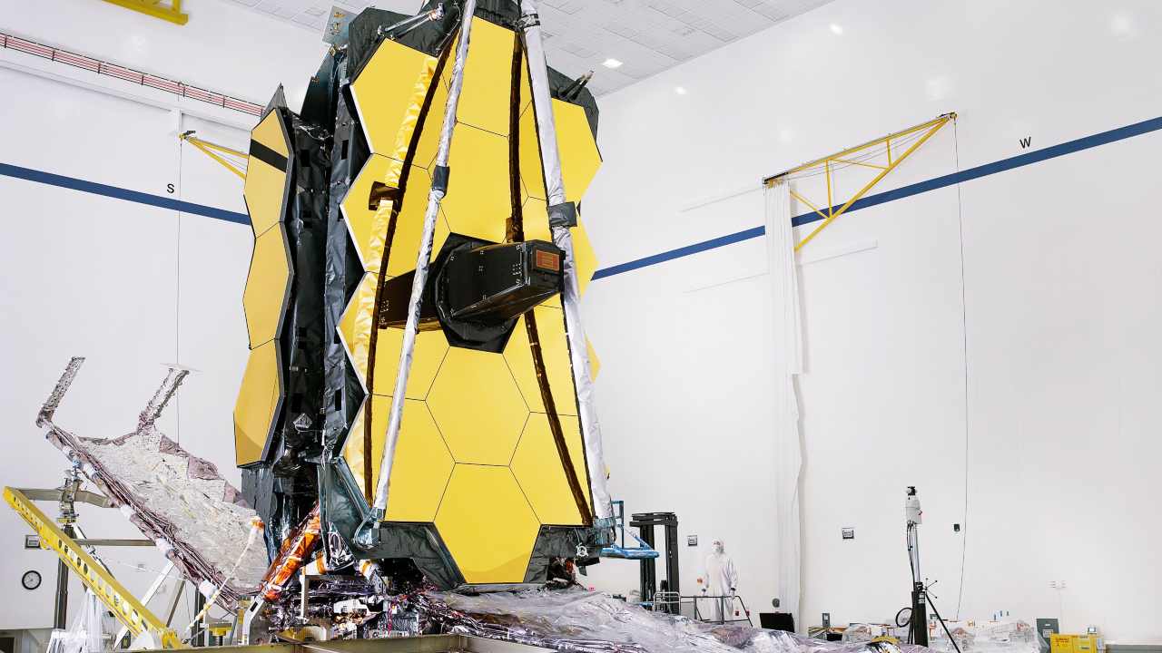 The fully assembled James Webb Space Telescope with its sunshield and 'unitized pallet structures' (which fold up around the telescope for launch) are seen partially deployed to an open configuration for telescope installation. Image: NASA/Chris Gunn