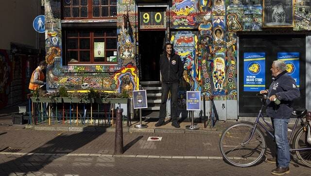 An employee stands outside a coffee shop in the Red Light District of Amsterdam in March 2021. (Ilvy Njiokiktjien/The New York Times)
