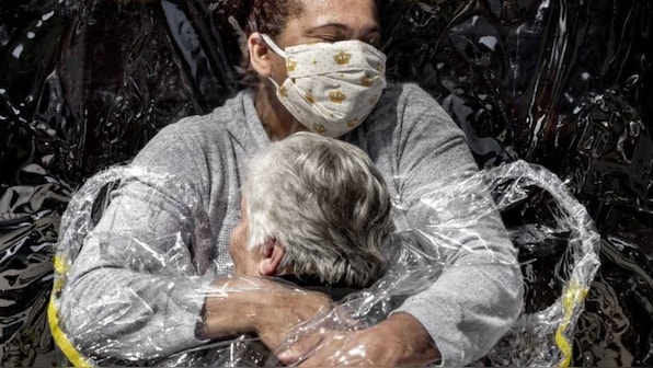 Nurse embracing patient in Brazil wearing 'hug curtain' wins World Press Photo of the Year