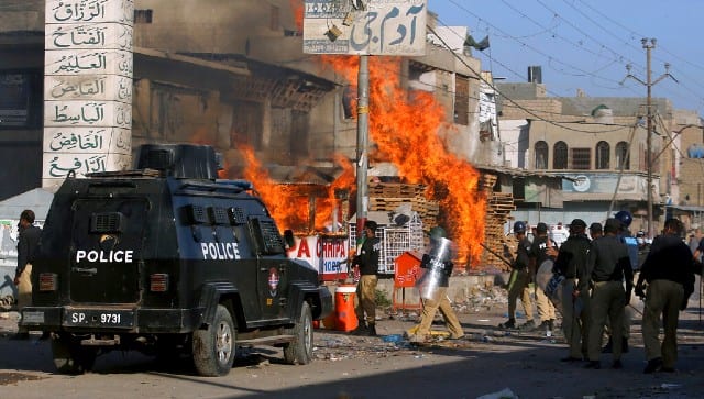 Police officers arrive to confront angry supporters of Tehreek-e-Labbaik Pakistan, a radical Islamist political party, who set fires during protests following the arrest of their party leader Saad Rizvi. AP