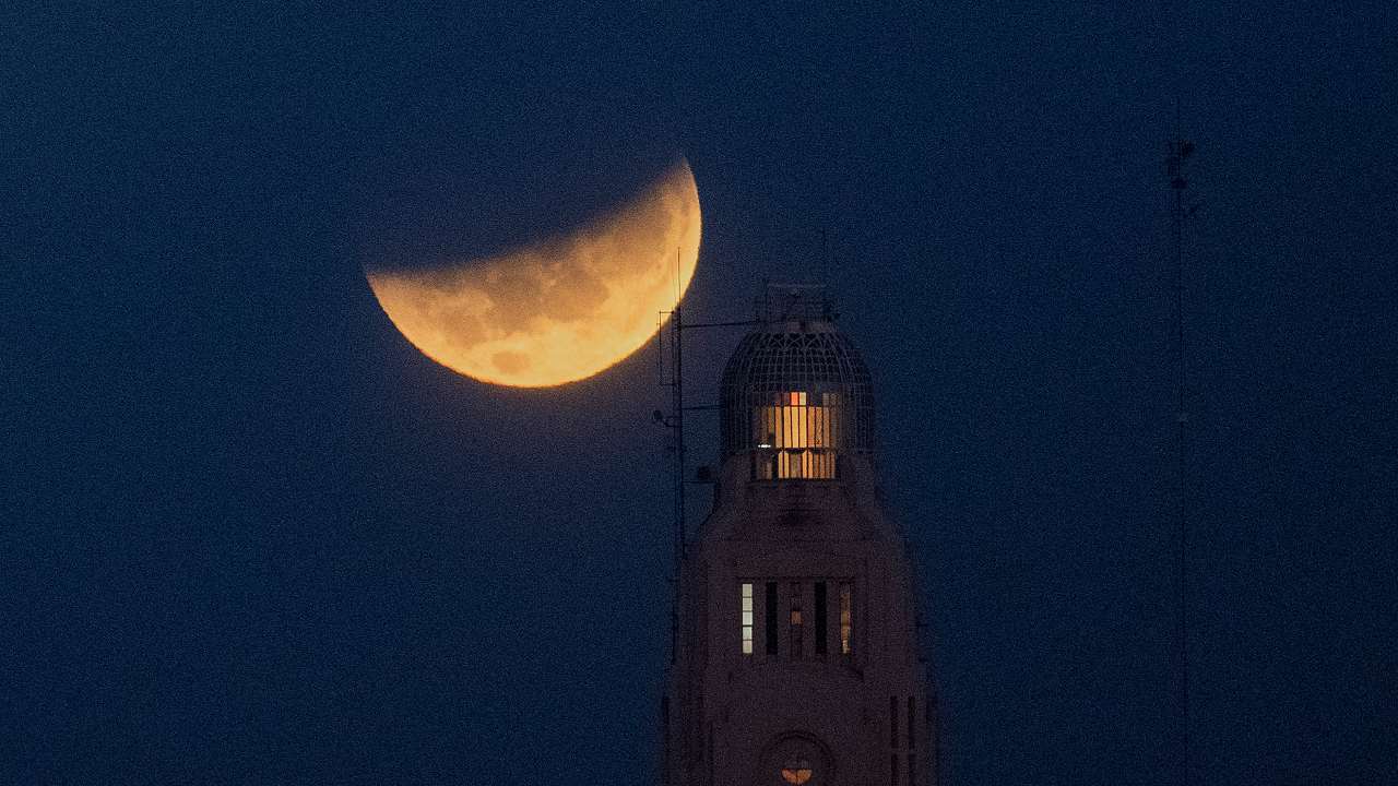 The moon sets behind the Montevideo port, in Uruguay. For a small period of time, the eclipse was visible from the northeastern parts of India (except Sikkim), some parts of West Bengal, some coastal parts of Odisha and Andaman and the Nicobar Islands. Image credit: AP Photo/Matilde Campodonico