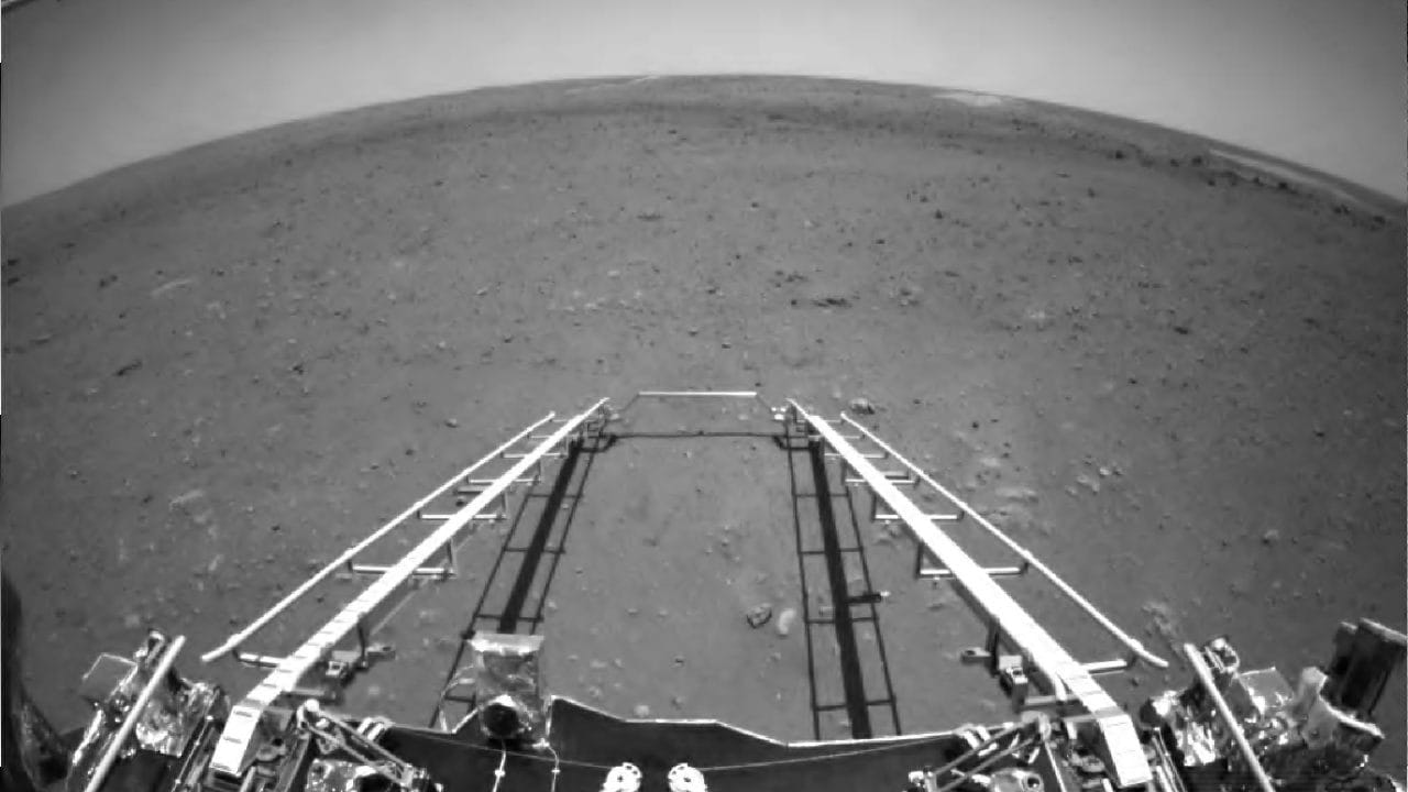 was captured by the obstacle avoidance camera installed in front of the Mars rover. One can see the ramp extending from the lander to Mars' rocky surface. One gets a glimpse of the terrain ahead of the lander and the horizon of Mars appears to be curved due to the wide-angle lens. Image credit: CNSA via AP 