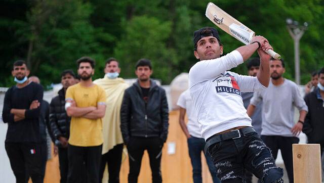 A batter hits the ball as migrants play a game of cricket in Blazuj migrant camp in Bosnia's capital of Sarajevo.AP