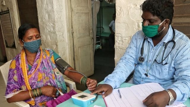 Dr Sachin Salave, CHO at Bhuye PHC, checking the blood pressure of people with comorbidities before they get vaccinated. 