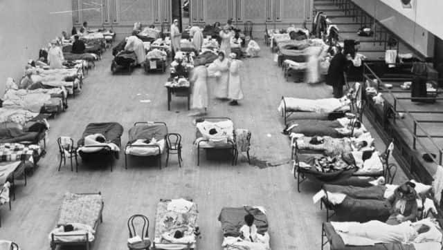 An image of American Red Cross nurses tending to influenza patients in 1918. Image via The Associated Press