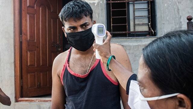 Rehana Mujawar, one of the 14 ASHA workers from Tardal, monitoring the temperature of a villager