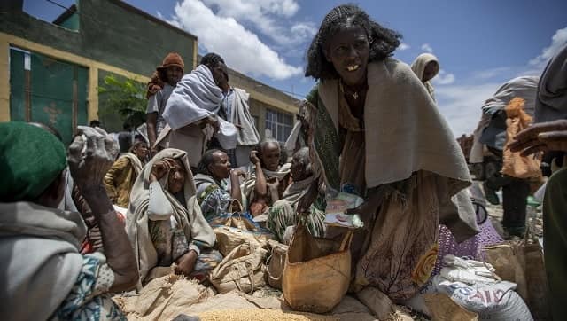 An Ethiopian woman leaves with a portion of peas, distributed by the Relief Society of Tigray. Photo by AP/Ben Curtis