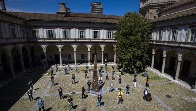 Jazz orchestra musicians and singers wear face masks and practise at the Giuseppe Verdi Music Conservatory's cloister before a rehearsal, in Milan, Italy. Image via The Associated Press/Antonio Calanni