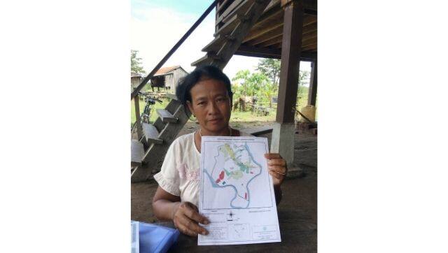 Village head Srang Lanh holds a map of the new village of Kbal Romeas, where 52 families who rejected the government’s resettlement deal have opted to live (Image: Sangeetha Amarthalingam)