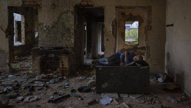 A homeless Lebanese man sleeps on a refrigerator inside an old deserted house in Beirut. Image via The Associated Press/ Hassan Ammar
