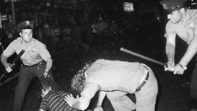 A 1970 file photo that shows an NYPD officer grabs a youth by the hair as another officer clubs a young man during a confrontation in Greenwich Village after a Gay Power march in New York. Image via The Associated Press