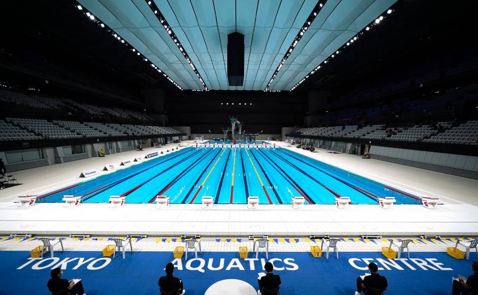 FILE - In this April 26, 2021, file photo, Tokyo 2020 Olympic Games Organizing staff prepare a Paralympic swimming test event at the Tokyo Aquatics Center, one of the venues of the Tokyo 2020 Olympic and Paralympic Games, in Tokyo. Public sentiment in Japan has been generally opposed to holding the Tokyo Olympics and Paralympics. This is partly based of fears the coronavirus will spike as almost 100,000 people — athletes and others — enter for both events.(AP Photo/Eugene Hoshiko, File)