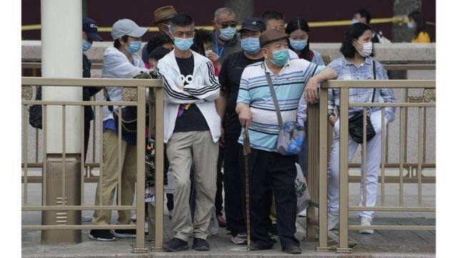 Visitors wait at a bus stop in the Tiananmen Square area in Beijing on Wednesday, 2 June, 2021. Photo via The Associated Press/Ng Han Guan.