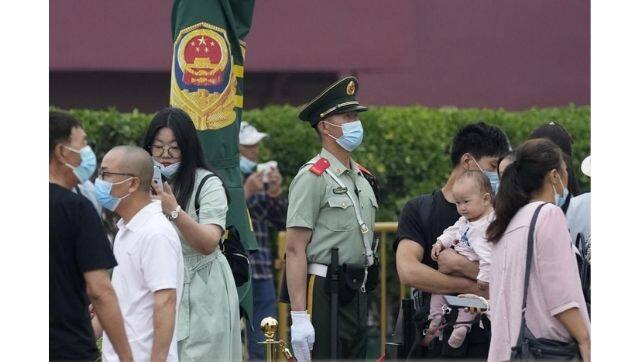 A paramilitary police officer stands guard as visitors pass near the Tiananmen Gate in Beijing on Wednesday, 2 June, 2021. Photo via The Associated Press/Ng Han Guan