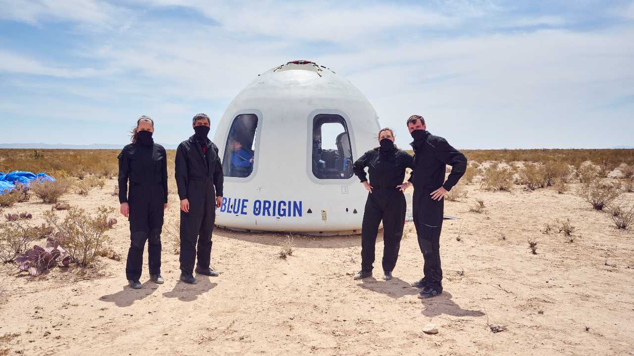 Le personnel de Blue Origin debout en tant qu'astronautes pendant la mission NS-15 pose devant la capsule de l'équipage New Shepard après une mission réussie.  (14 avril 2021) Crédit image : Blue Origin